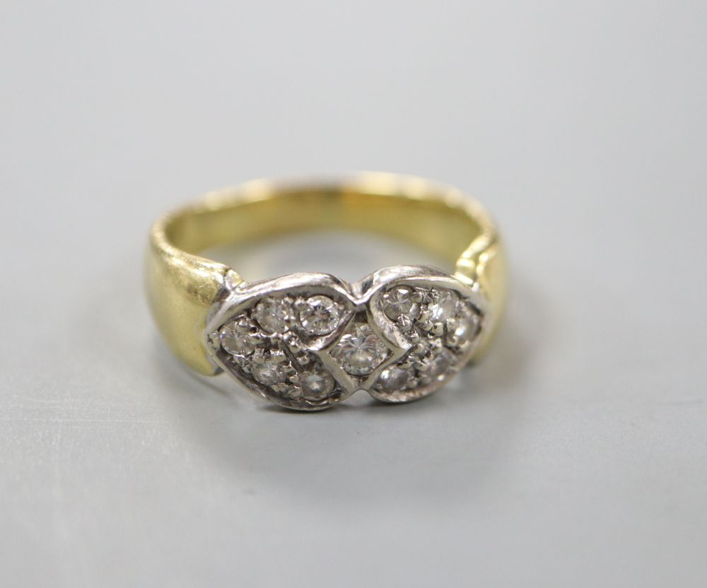 A modern 750 and eleven stone diamond set twin hearts dress ring, size N, gross 5.1 grams.
